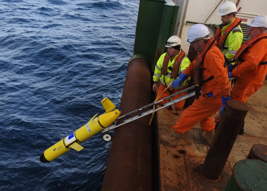 Men launching a glider to the sea